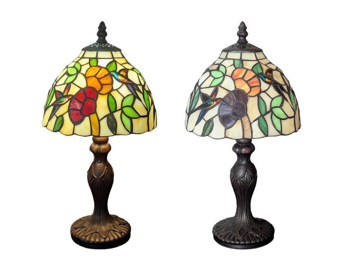 Two Tiffany-style stained glass table lamps with bird and floral designs, shown side by side against a white background.