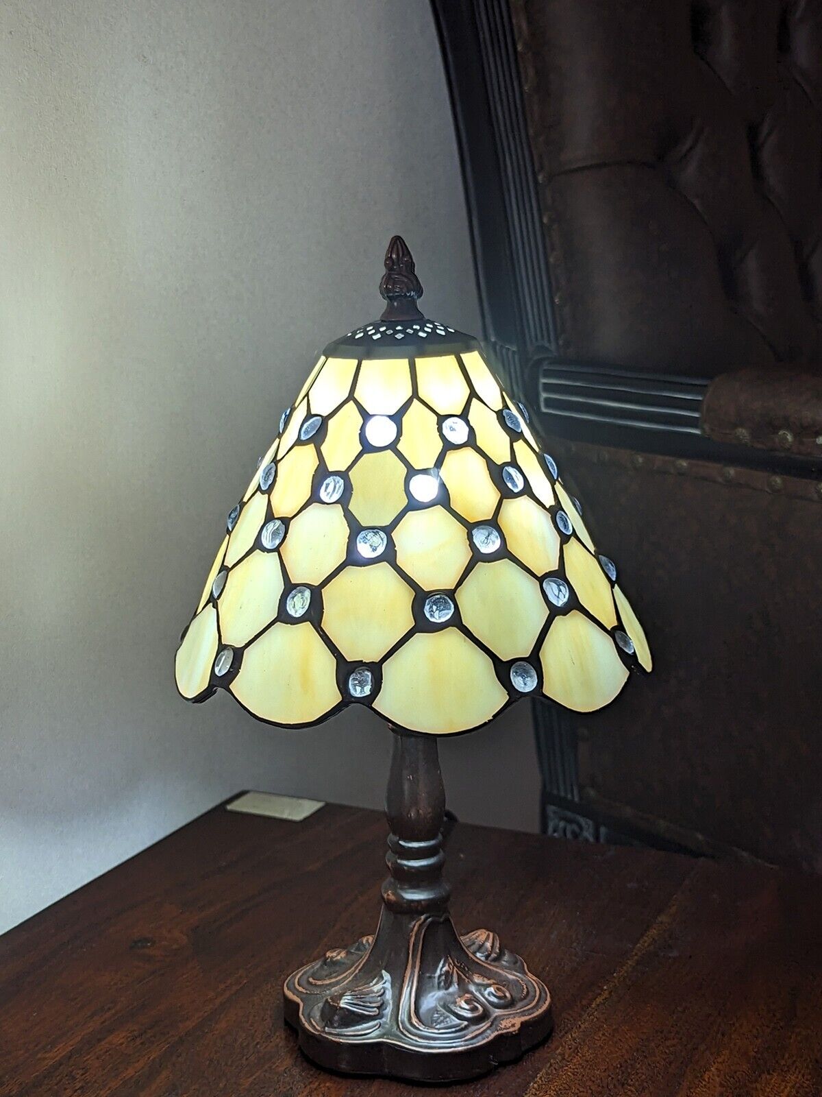 Decorative table lamp with stained glass shade on a wooden surface.