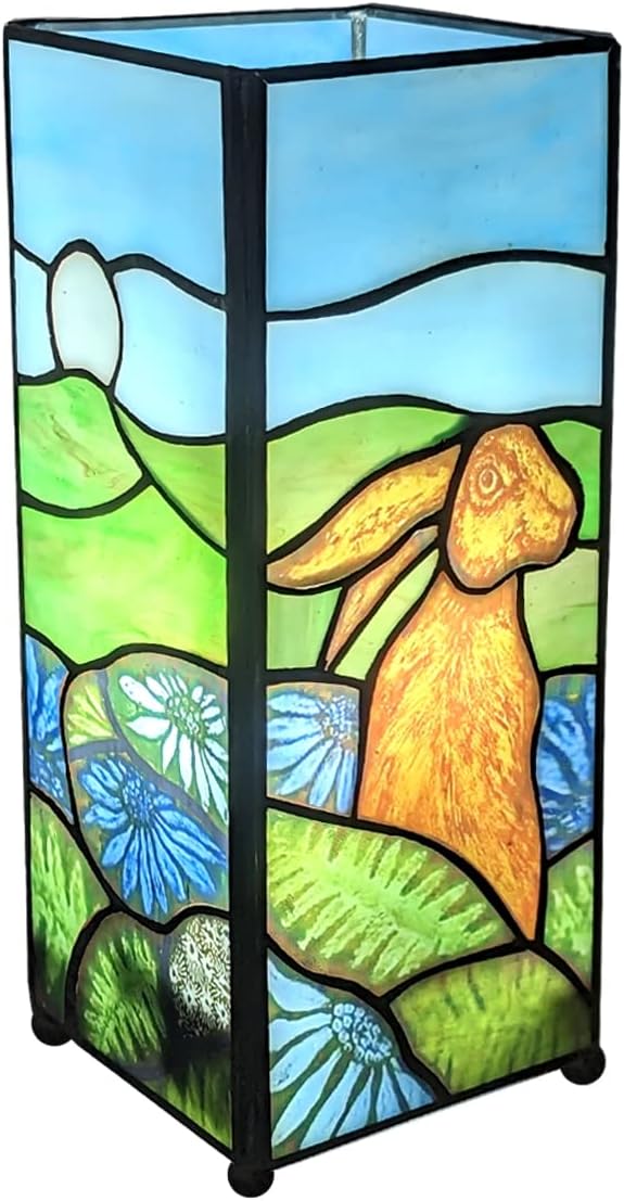 A square Tiffany-style lamp with a black base and a stained glass panel featuring a rabbit design, set against a backdrop of a pastoral landscape with flowers.