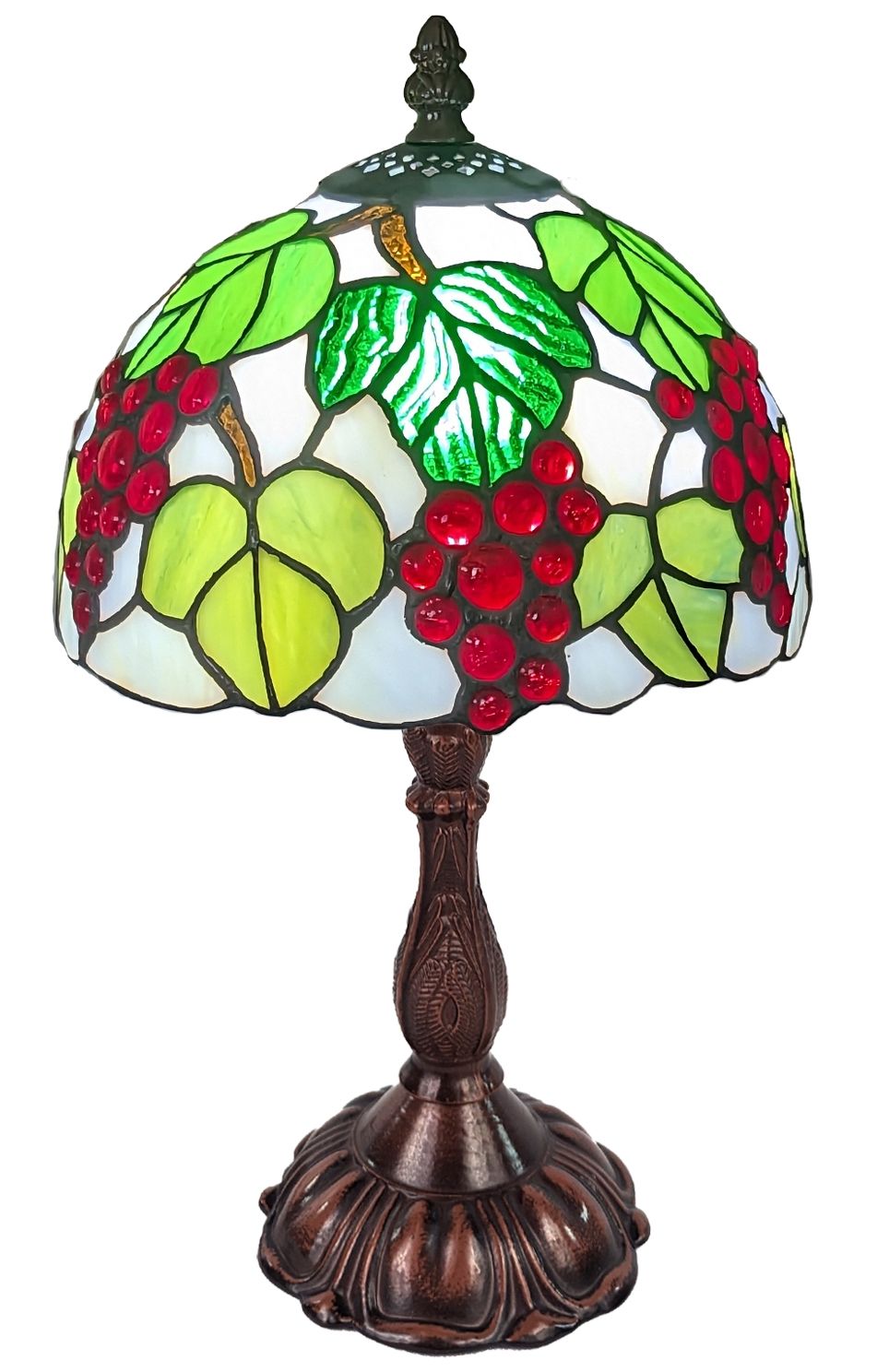 A Tiffany-style stained glass table lamp featuring a grapevine design with green leaves, red grape clusters, and a dark bronze metal base and stem.