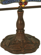 Close-up of a decorative table lamp base and stem in a dark bronze finish, with a stained-glass wing detail showing blue, yellow, and red accents at the top, on a white background.