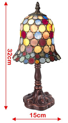 A stained glass table lamp with a multicolor circular shade and a dark bronze base, shown on a white background with red dimension arrows and text indicating 32 cm height and 15 cm width.