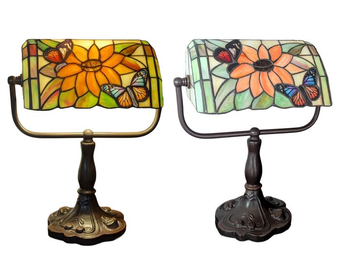 Two Tiffany-style stained glass desk lamps with sunflower and butterfly motifs, shown side by side against a white background.