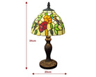 A stained glass table lamp with a floral design, featuring a dark bronze base and a multi-colored shade with yellow, green, red, and orange glass panels. Red dimension arrows and text labels indicate a height of 34cm and a width of 20cm on a plain white background.