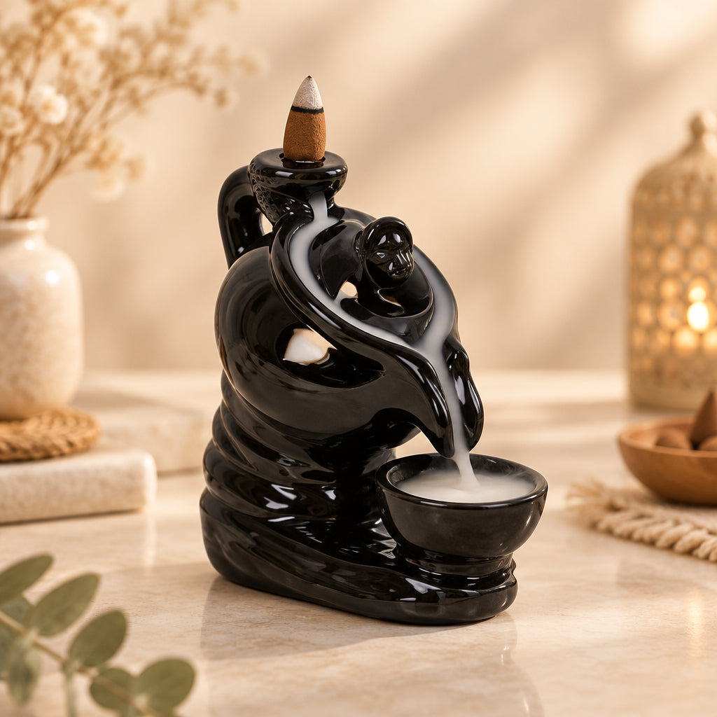A black ceramic incense burner designed to resemble a teapot with a backflow cone on top and a cup below for collecting smoke.
