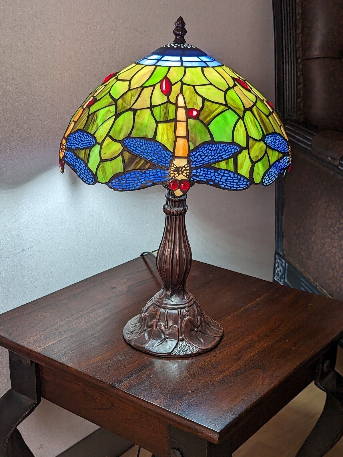 Stained glass lamp with dragonfly design on a wooden table