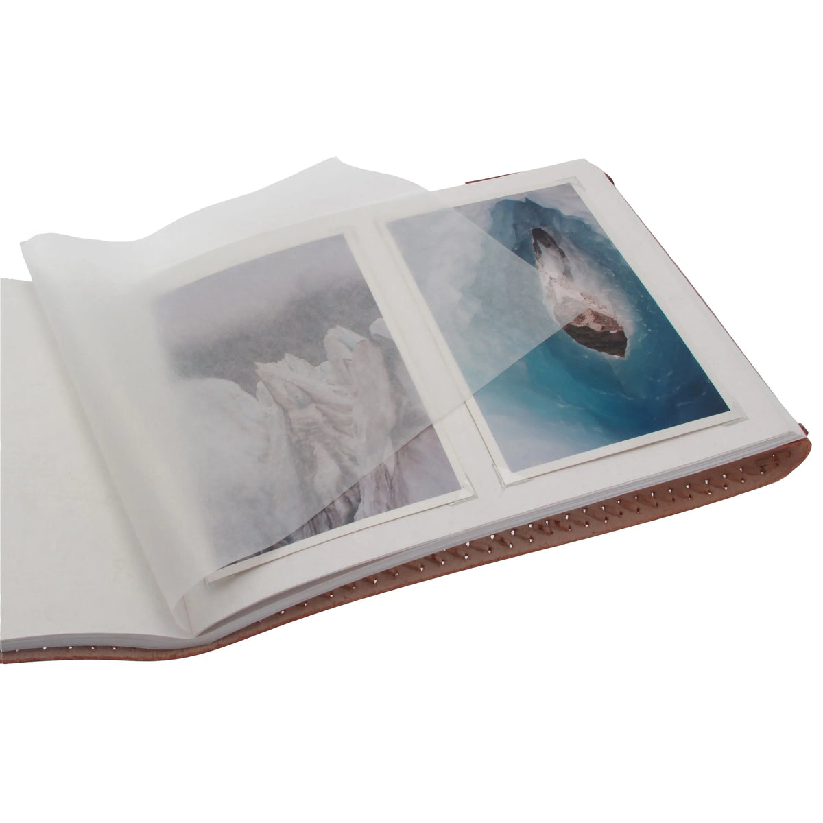 An open leather-bound photo album with two translucent protective sleeves holding printed photographs, shown on a plain white background.