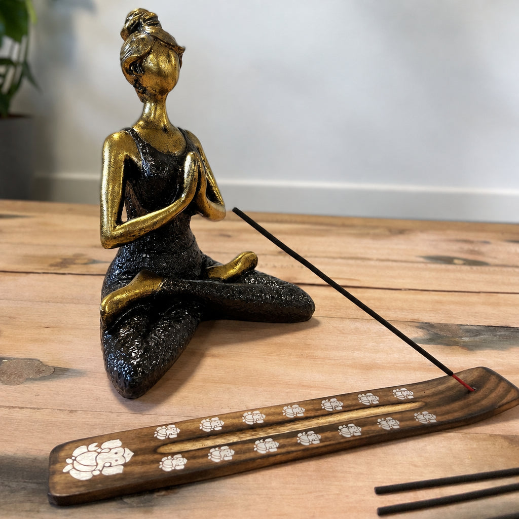 Decorative statue of a woman with incense on a wooden table