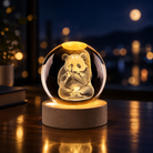 A glowing crystal snow globe featuring an intricately carved panda sitting cross-legged, set on a round illuminated wooden base. The scene is photographed on a dark wooden table with a softly blurred night cityscape background.