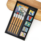Set of wooden chopsticks with decorative ends in a black box on a wooden surface